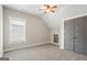Empty bedroom features closet doors, and a window allowing natural light, with neutral carpeting and paint at 5124 N Pratt St, Covington, GA 30014