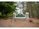Entrance to Georgian Park Condominiums with brick sign set in a serene, wooded setting at 702 Las Brasis Ct, Peachtree City, GA 30269