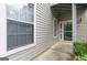 Exterior shot of the townhome front entrance featuring beige siding, and a storm door at 702 Las Brasis Ct, Peachtree City, GA 30269