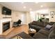 Spacious living room features a fireplace, a dark sofa and laminate floors throughout at 702 Las Brasis Ct, Peachtree City, GA 30269