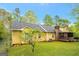 Backyard view with a screened porch, featuring lush green grass and mature trees at 4050 Old Fairburn Rd, Atlanta, GA 30349