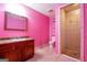 Pink bathroom featuring a tiled shower, tile floors, a dark vanity, and a mirrored medicine cabinet at 4050 Old Fairburn Rd, Atlanta, GA 30349