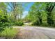 Long, private driveway leading to a house surrounded by mature trees and greenery at 4050 Old Fairburn Rd, Atlanta, GA 30349