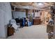 Unfinished basement with painted brick wall, exposed beams, and stored furniture and household items at 500 Hayfield Ct, Locust Grove, GA 30248