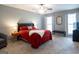 Comfortable bedroom features a ceiling fan, plush carpet, and an inviting red comforter at 500 Hayfield Ct, Locust Grove, GA 30248