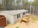 A view of the home exterior, showing a wooden porch, siding, and a red storage shed at 133 Springer Rd, Whitesburg, GA 30185