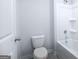 Neutral colored bathroom with a white toilet and bathtub/shower combo at 161 Aster Ave, Locust Grove, GA 30248
