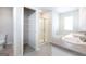 Bright bathroom with double sinks, tile floor, a soaking tub, and a glass-enclosed shower at 161 Aster Ave, Locust Grove, GA 30248