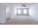 Large bedroom with plush carpet, two windows for natural light, and a ceiling fan at 161 Aster Ave, Locust Grove, GA 30248