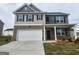 Two-story home features a two-car garage, a covered entry, and a mixed material facade, enhancing curb appeal at 161 Aster Ave, Locust Grove, GA 30248