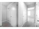 Bright hallway featuring neutral walls, modern doors, and gray flooring leading to bedrooms at 161 Aster Ave, Locust Grove, GA 30248