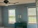Bedroom featuring a ceiling fan, desk with lamp, and windows with blinds at 9340 Basswood Way, Jonesboro, GA 30236