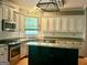 This kitchen features a dark island, stainless appliances, and granite countertops at 9340 Basswood Way, Jonesboro, GA 30236