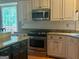 Bright kitchen with white cabinets, a view to the backyard, and stainless steel appliances at 9340 Basswood Way, Jonesboro, GA 30236