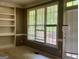 Living room featuring built-in shelving, large windows, and a door to the patio at 9340 Basswood Way, Jonesboro, GA 30236