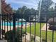 Community pool featuring lounge chairs, umbrellas, a sun deck, and well-manicured lawn at 9340 Basswood Way, Jonesboro, GA 30236