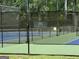 Outdoor tennis court with green and blue surface and a surrounding fence at 9340 Basswood Way, Jonesboro, GA 30236