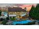 Aerial view of the home's backyard featuring a pool, outdoor kitchen, and screened-in porch at twilight at 119 Brookgrove Ln, Peachtree City, GA 30269