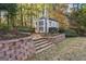A small shed in this backyard on a small retaining wall in a yard surrounded by trees at 119 Brookgrove Ln, Peachtree City, GA 30269