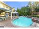 In-ground pool and brick patio at this home with an outdoor kitchen, covered porch, and surrounding trees at 119 Brookgrove Ln, Peachtree City, GA 30269