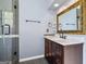 Bathroom featuring a dark wood vanity with light countertops, a decorative mirror, and a glass shower door at 119 Brookgrove Ln, Peachtree City, GA 30269