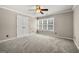 Cozy bedroom with neutral walls, plush carpet, and a window providing plenty of natural light at 119 Brookgrove Ln, Peachtree City, GA 30269