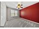 Bedroom with neutral carpet, red accent wall, and ceiling fan at 119 Brookgrove Ln, Peachtree City, GA 30269