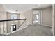 Carpeted hallway overlooking the foyer and staircase through decorative window at 119 Brookgrove Ln, Peachtree City, GA 30269