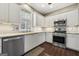Modern kitchen features white cabinets, stainless steel appliances, granite countertops, and hardwood floors at 119 Brookgrove Ln, Peachtree City, GA 30269