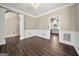 Open room featuring hardwood floors and elegant wall paneling, leading to the kitchen and staircase at 119 Brookgrove Ln, Peachtree City, GA 30269