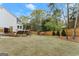 Expansive backyard with mature trees, a deck, and a well-maintained lawn at 735 River Ridge Ln, Suwanee, GA 30024