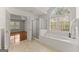 Elegant bathroom with a glass shower, soaking tub, and view of the backyard at 735 River Ridge Ln, Suwanee, GA 30024
