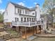 Rear exterior of home showcases the deck, lower patio, and well-manicured landscaping at 735 River Ridge Ln, Suwanee, GA 30024