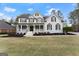 Beautifully landscaped yard with charming two-story home, black shutters, and inviting entrance at 735 River Ridge Ln, Suwanee, GA 30024