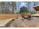 Stone patio with a fire pit, seating, and views of the landscaped backyard at 735 River Ridge Ln, Suwanee, GA 30024