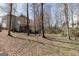 Large backyard with mature trees, a play area, and a view of the two-story house at 2032 Stonewick Ct, Lawrenceville, GA 30043