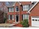Charming two-story brick home with black shutters, a well-manicured lawn, and attached garage at 2032 Stonewick Ct, Lawrenceville, GA 30043
