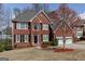 Charming two-story red brick home featuring a two-car garage and well-manicured landscaping at 2032 Stonewick Ct, Lawrenceville, GA 30043
