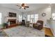 Spacious living room with hardwood floors, fireplace, large windows, and a ceiling fan at 2032 Stonewick Ct, Lawrenceville, GA 30043