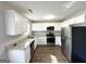 Bright kitchen featuring stainless steel appliances, white cabinets, granite counters, and hardwood floors at 173 Regency Park Dr, Mcdonough, GA 30253