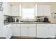 Well-lit kitchen featuring white cabinetry, laminate countertops, and a stainless steel sink at 2636 General Lee Ct, Buford, GA 30519