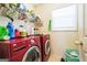 Laundry room with red washer and dryer and plenty of storage at 2636 General Lee Ct, Buford, GA 30519