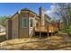 Rear view of a brick home with a deck overlooking a spacious lawn at 5265 Brookhollow Dr, Douglasville, GA 30135