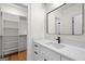Bathroom with white vanity, modern black hardware, and a walk-in closet with custom shelving at 5265 Brookhollow Dr, Douglasville, GA 30135