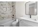 Bathroom featuring marble tiling, a tub/shower combo, and a vanity with a rectangular mirror at 5265 Brookhollow Dr, Douglasville, GA 30135