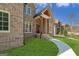 Close-up of beautiful brick home with covered entrance and wooden support beams at 5265 Brookhollow Dr, Douglasville, GA 30135