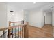 Bright hallway with hardwood floors features a statement chandelier and wood railing at 5265 Brookhollow Dr, Douglasville, GA 30135