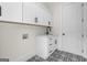 Laundry room featuring black and white mosaic tile floors, a utility sink and white cabinets at 5265 Brookhollow Dr, Douglasville, GA 30135