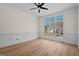 Bright, empty room featuring hardwood floors, wainscoting, and a large window offering neighborhood views at 5265 Brookhollow Dr, Douglasville, GA 30135