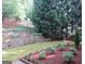 Landscaped backyard featuring a tiered garden bed and a wooden fence at 5860 Fairway View Dr, Suwanee, GA 30024